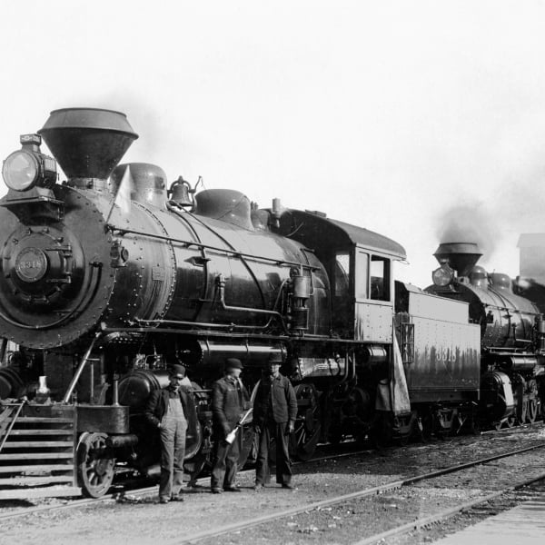 An old steam locomotive with workers outside of it