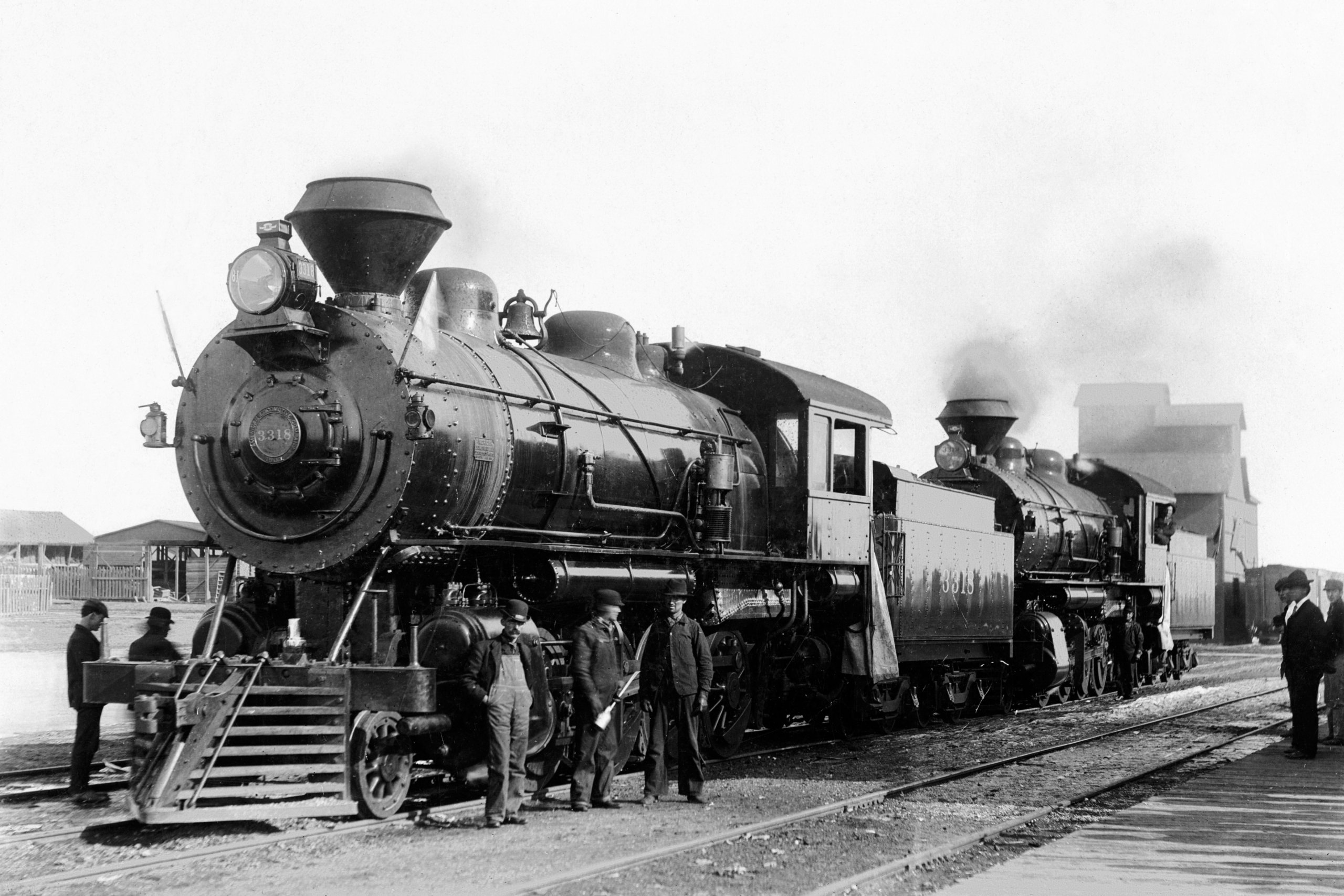 An old steam locomotive with workers outside of it