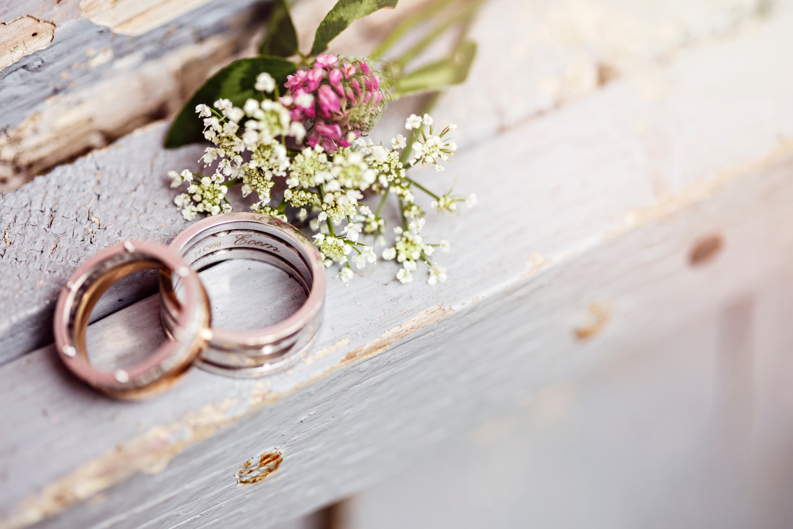 Two wedding rings next to flowers