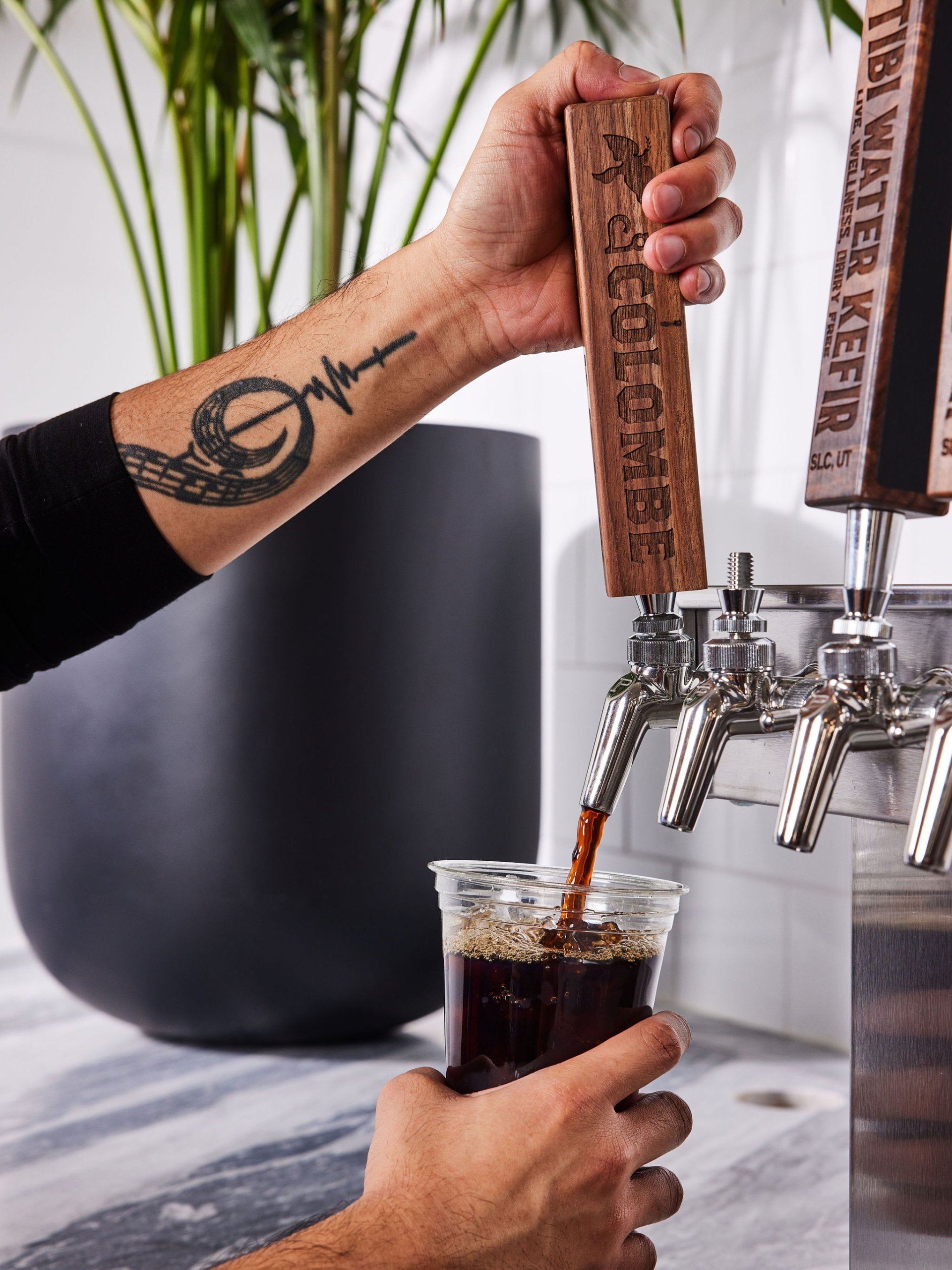 A barista pours cold brew from a large tap at Counterpart at Asher Adams Hotel, Salt Lake City