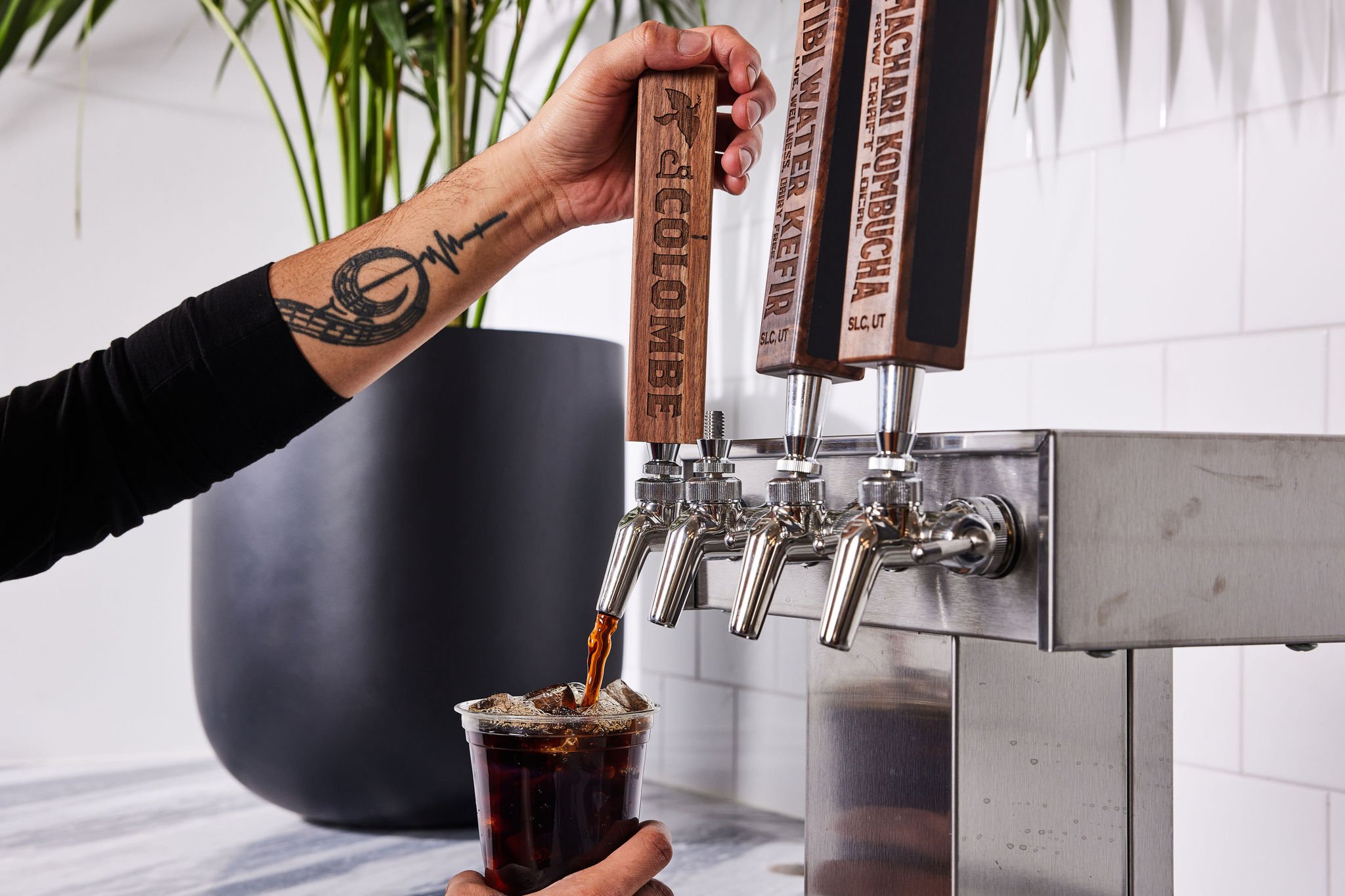 A barista pours cold brew from a large tap at Counterpart at Asher Adams Hotel, Salt Lake City