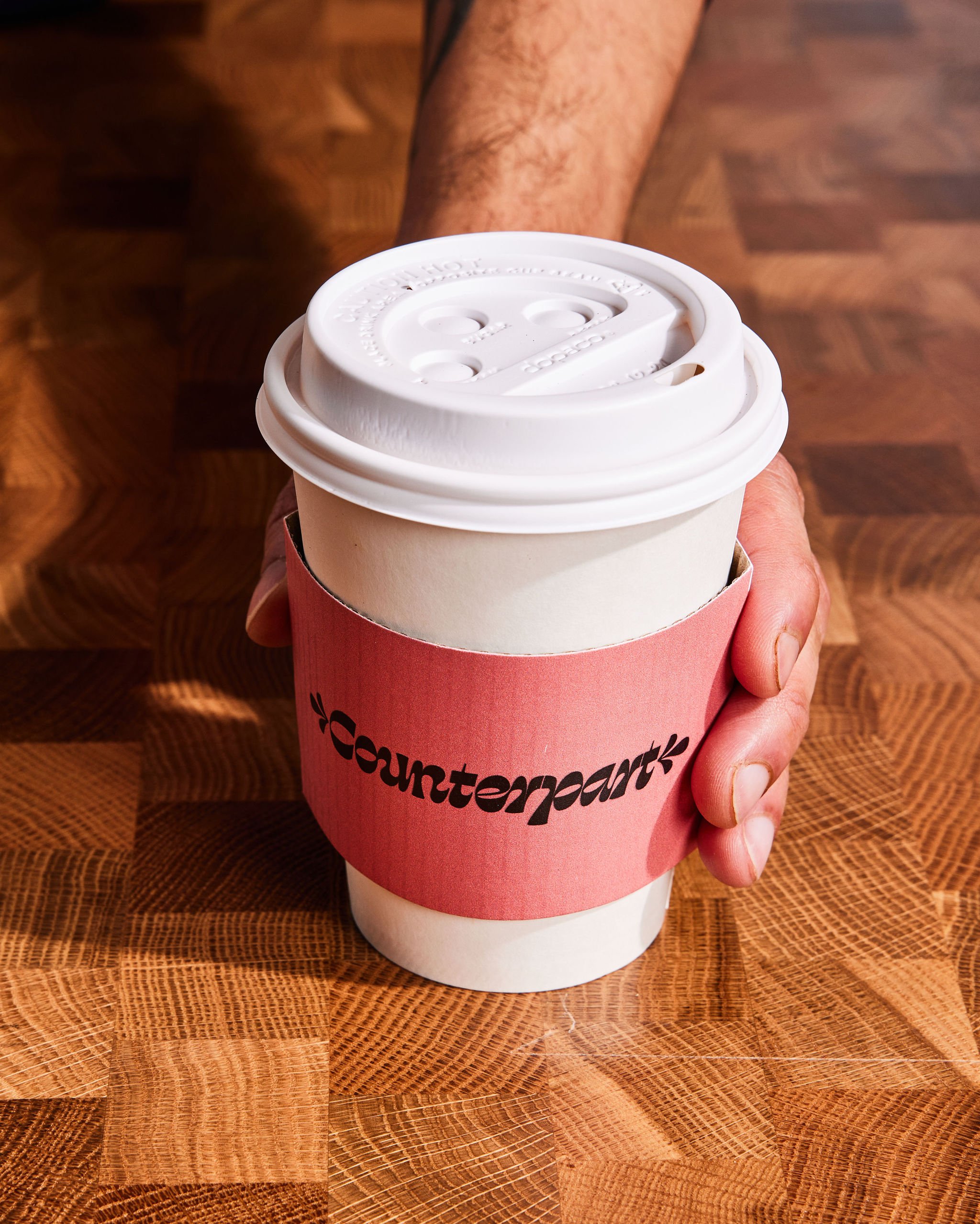 A barista places down a to-go coffee at Counterpart at Asher Adams Hotel, Salt Lake City