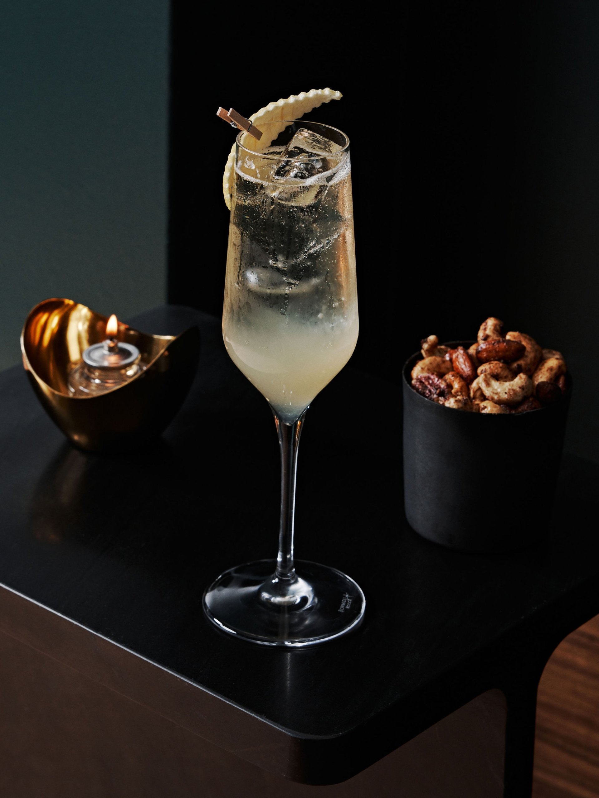 A cocktail in a flute glass next to assorted nuts at No. 119 at Asher Adams Hotel, Salt Lake City