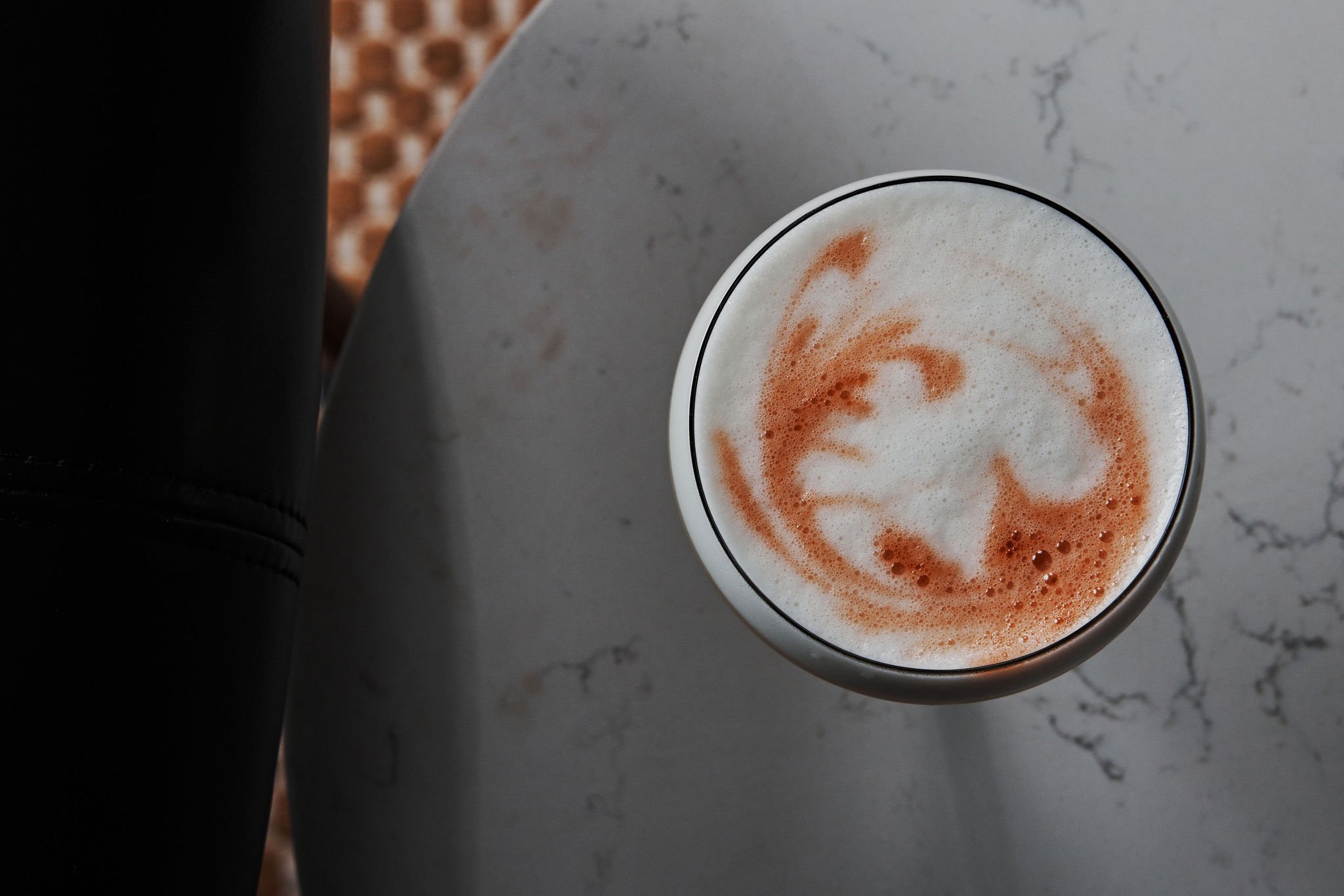 An overhead shot of a foamy cocktail from No. 119 at Asher Adams Hotel, Salt Lake City