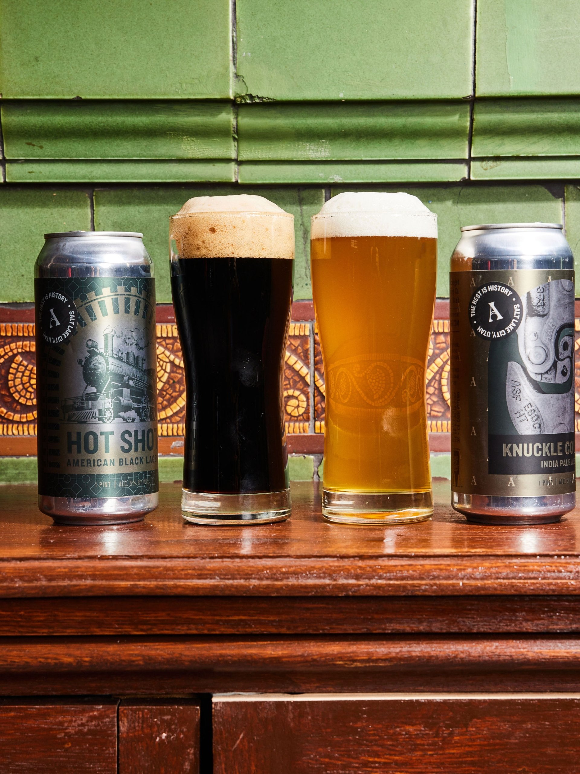 Two cans of beer branded with Asher Adams logo sit on an ornate bar at The Bar at Asher Adams, Salt Lake City