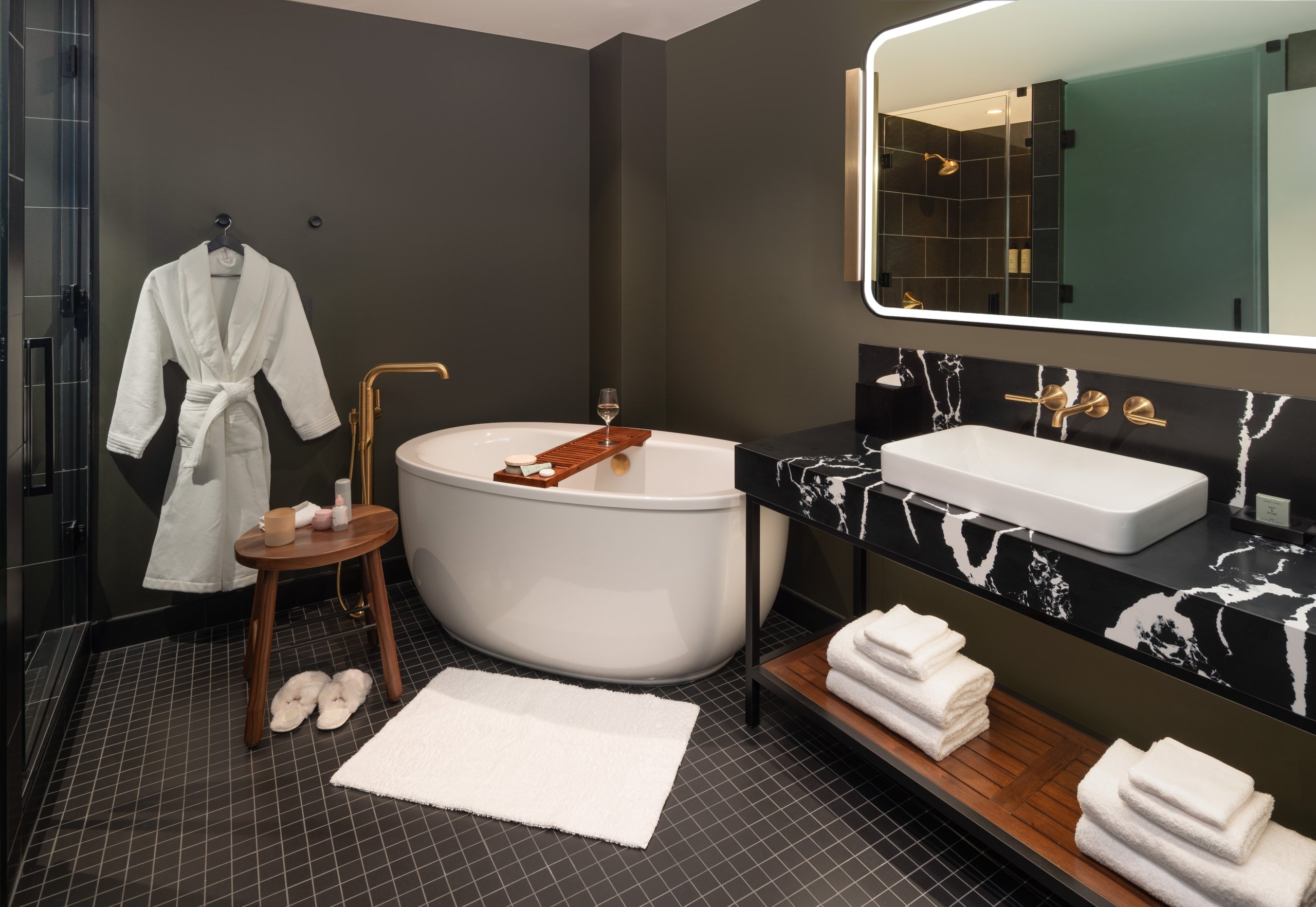 A bathroom with large soaking tub and robe in a suite at Asher Adams Hotel in Salt Lake City