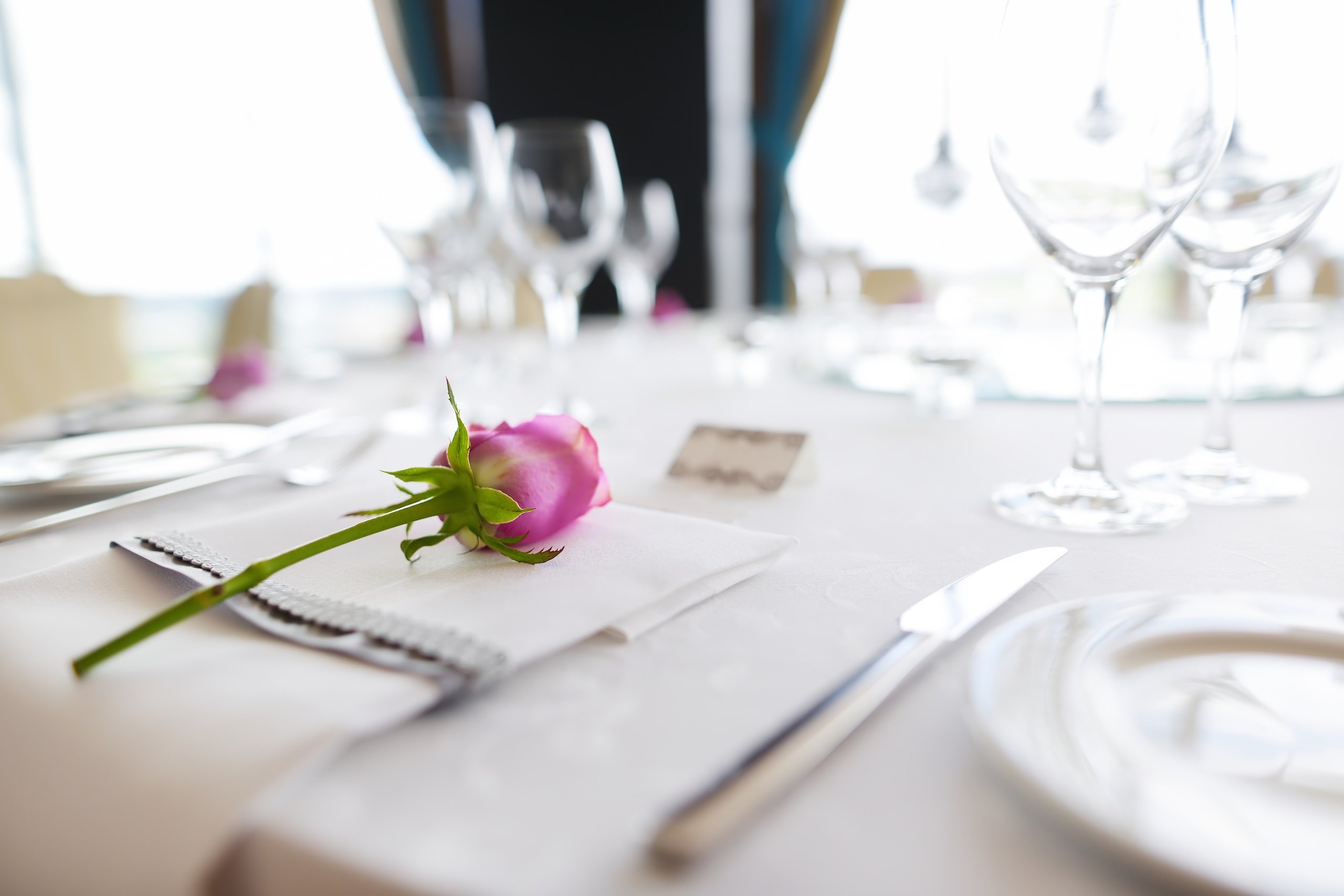 Glassware and cutlery for catered event dinner.