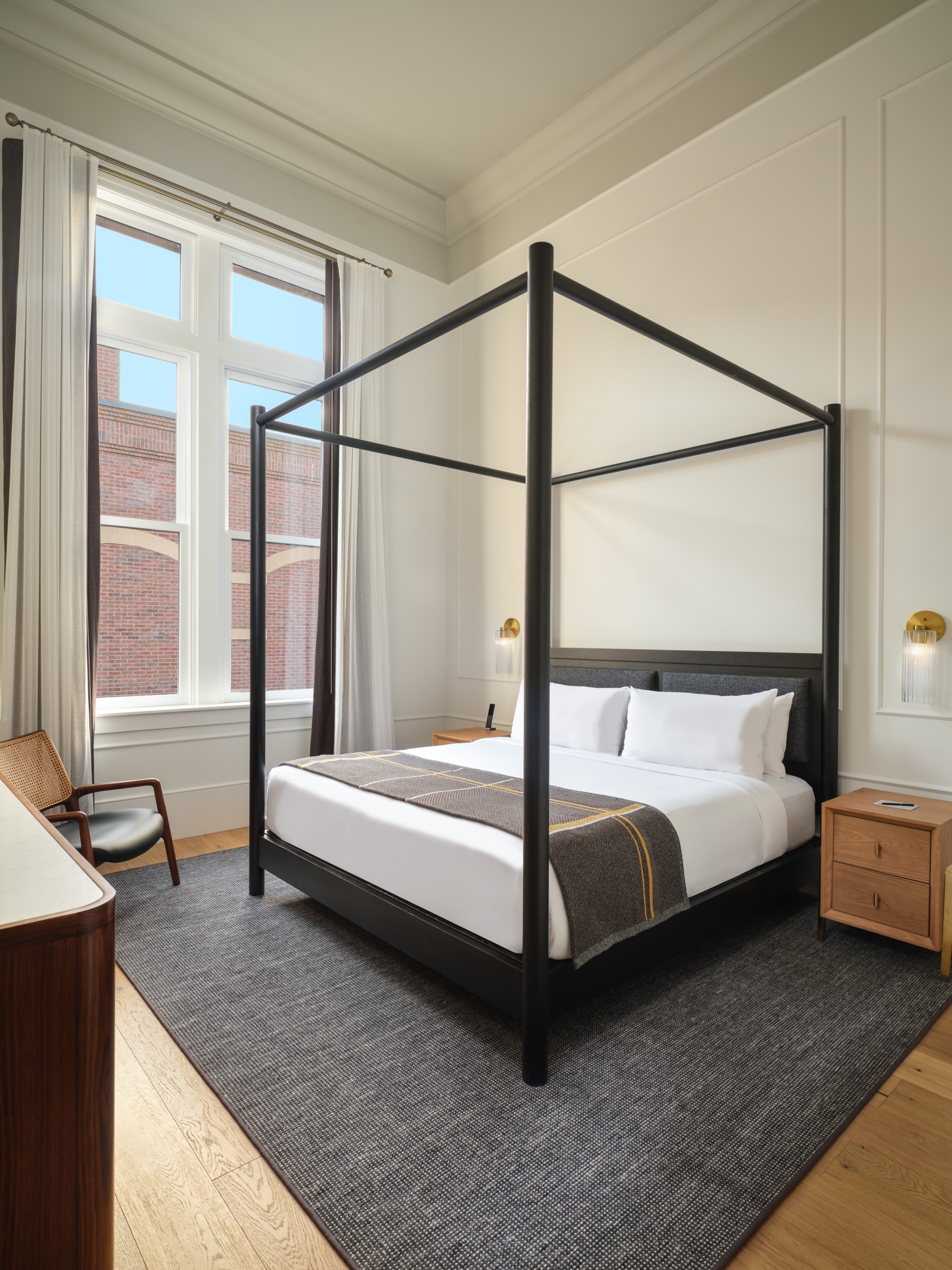 A four-poster bed and large windows in a suite at Asher Adams Hotel, Salt Lake City