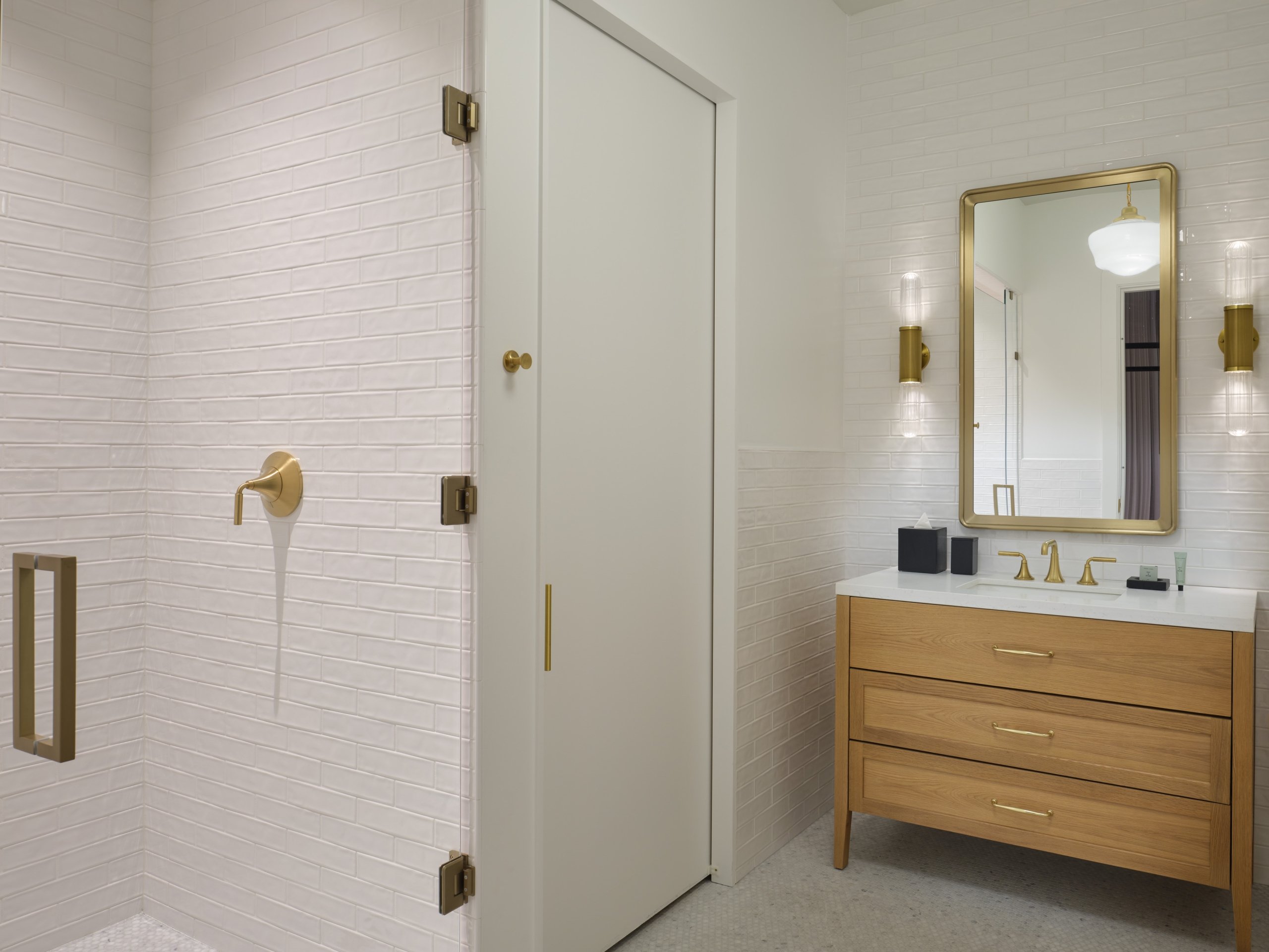 A bathroom with vanity and glass shower in a suite at Asher Adams Hotel, Salt Lake City