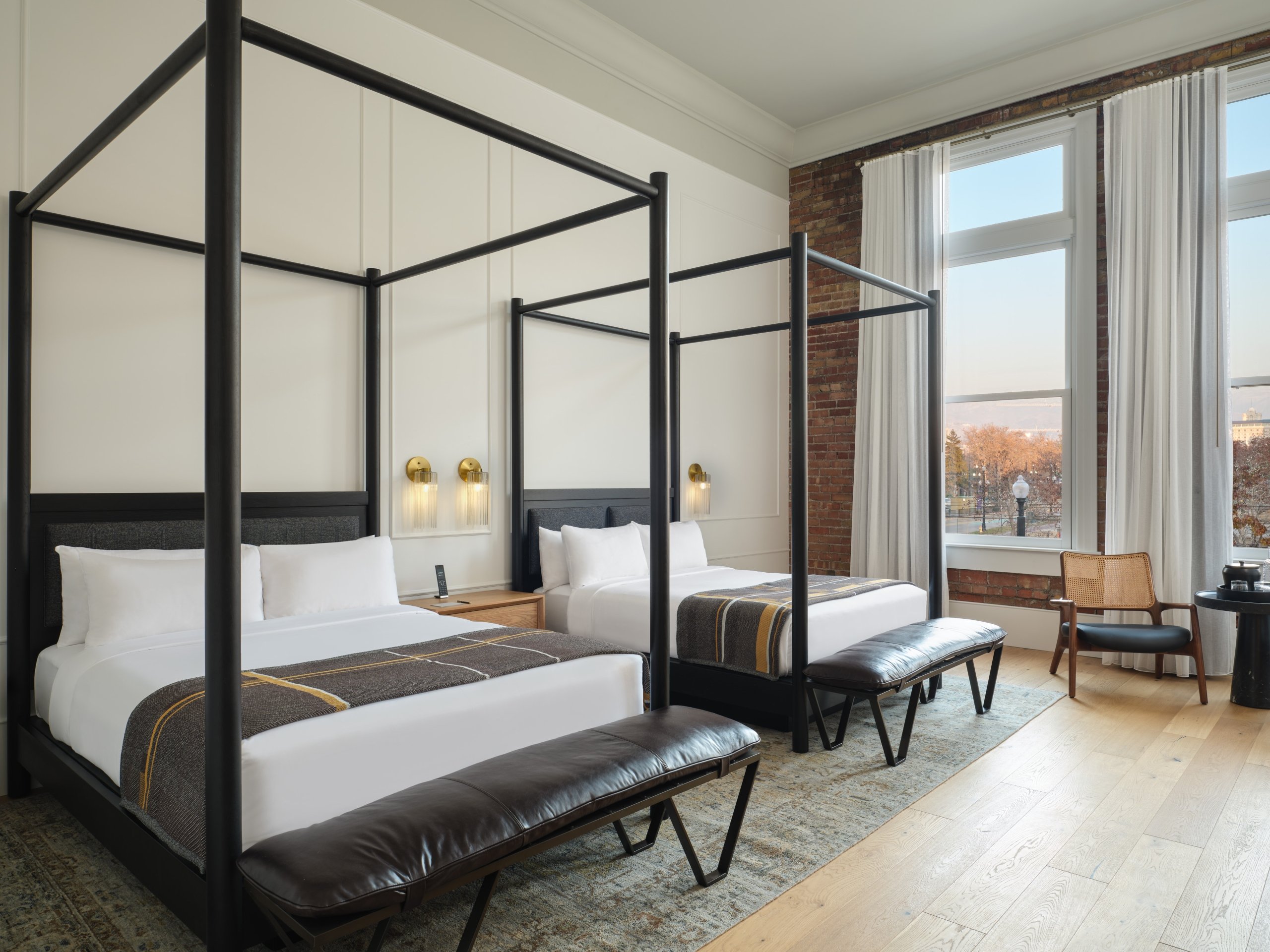 Two four-poster queen beds in a suite at Asher Adams Hotel, Salt Lake City