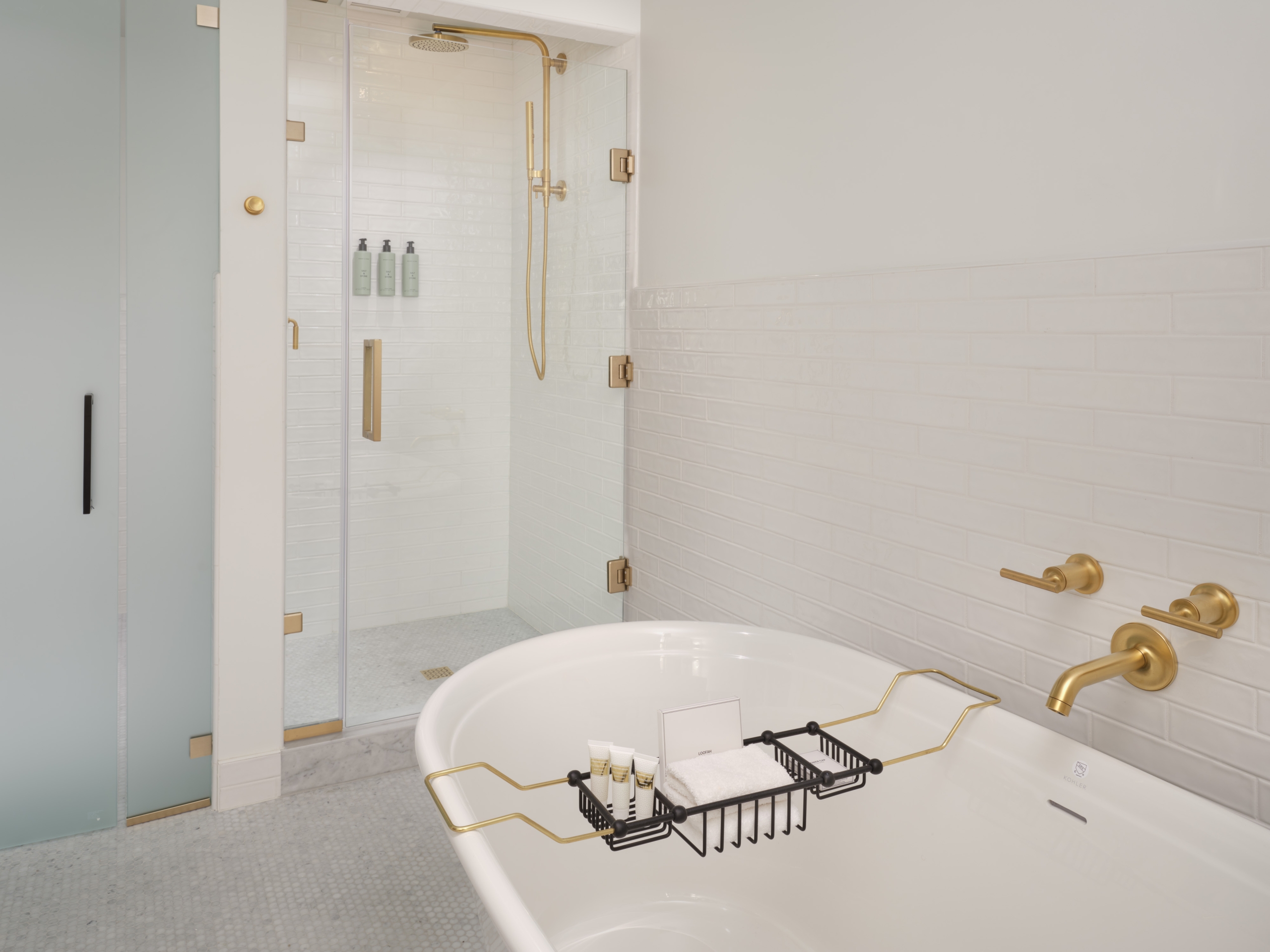 A large soaking tub and glass rain shower in a suite at Asher Adams Hotel, Salt Lake City