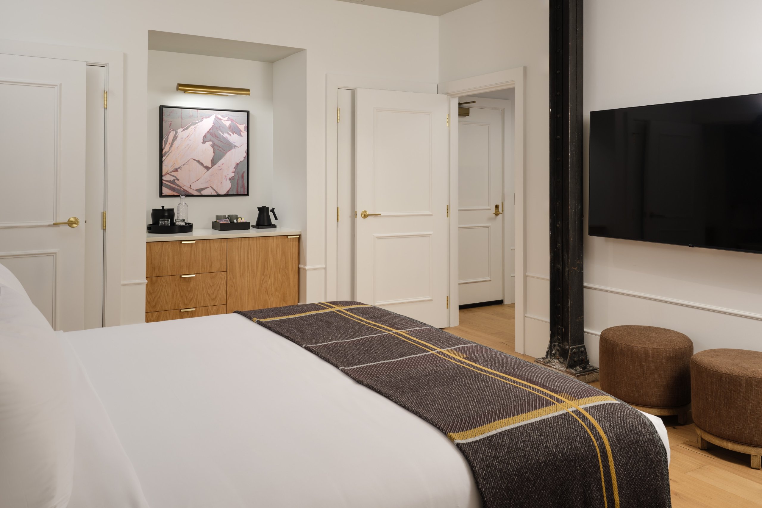 A bed and wall-mounted tv in a suite at Asher Adams Hotel, Salt Lake City